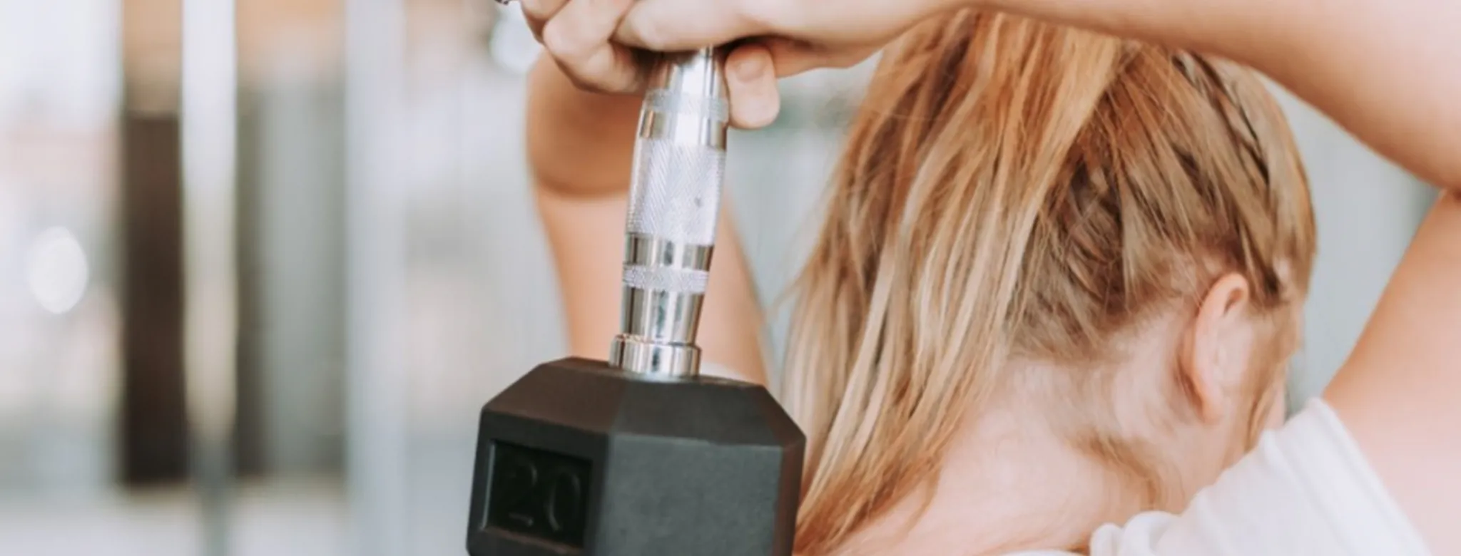 woman with blonde hair lift weight over her head
